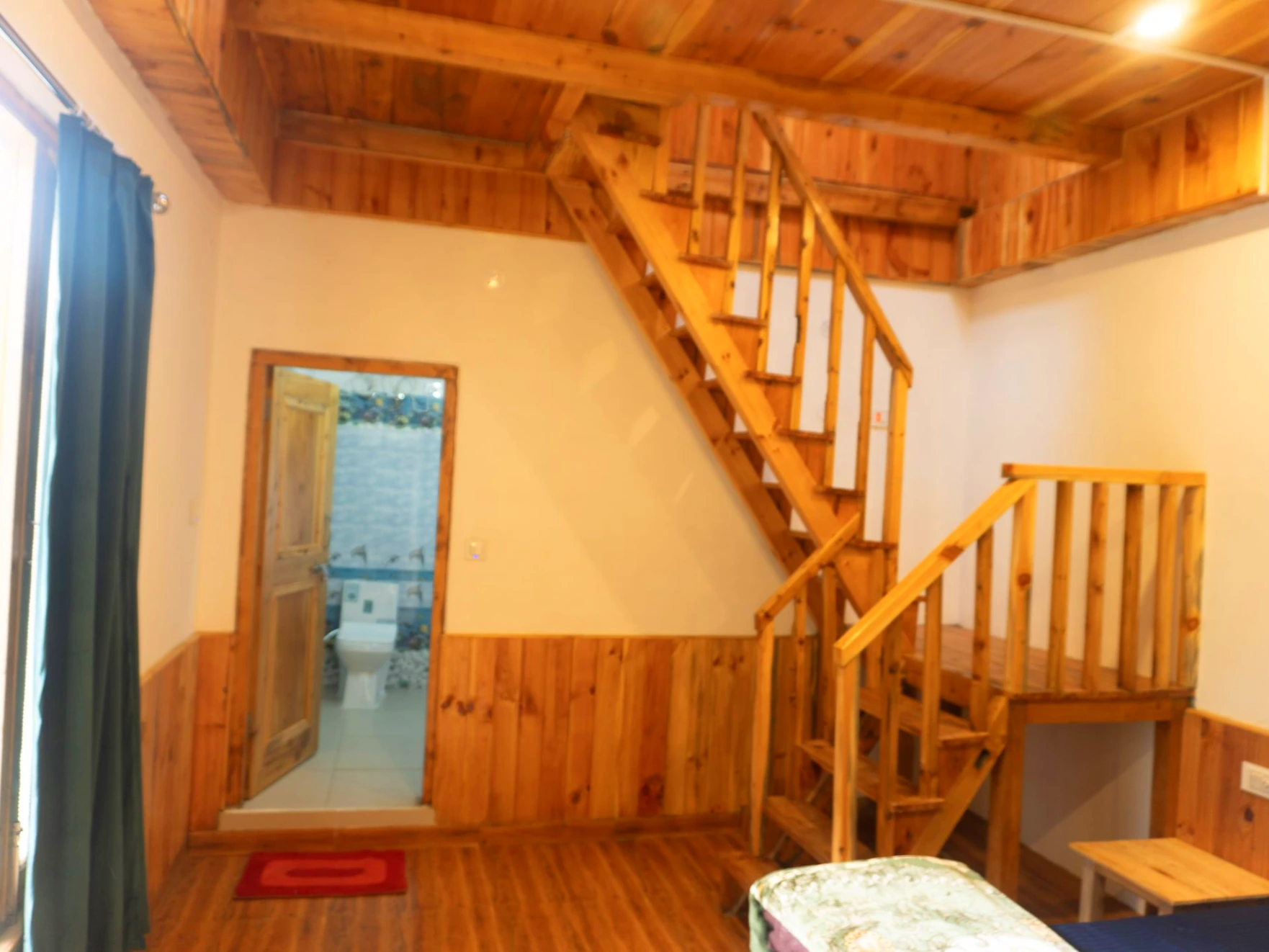 Duplex wooden room staircase at The River Haven Homestay in Tirthan Valley