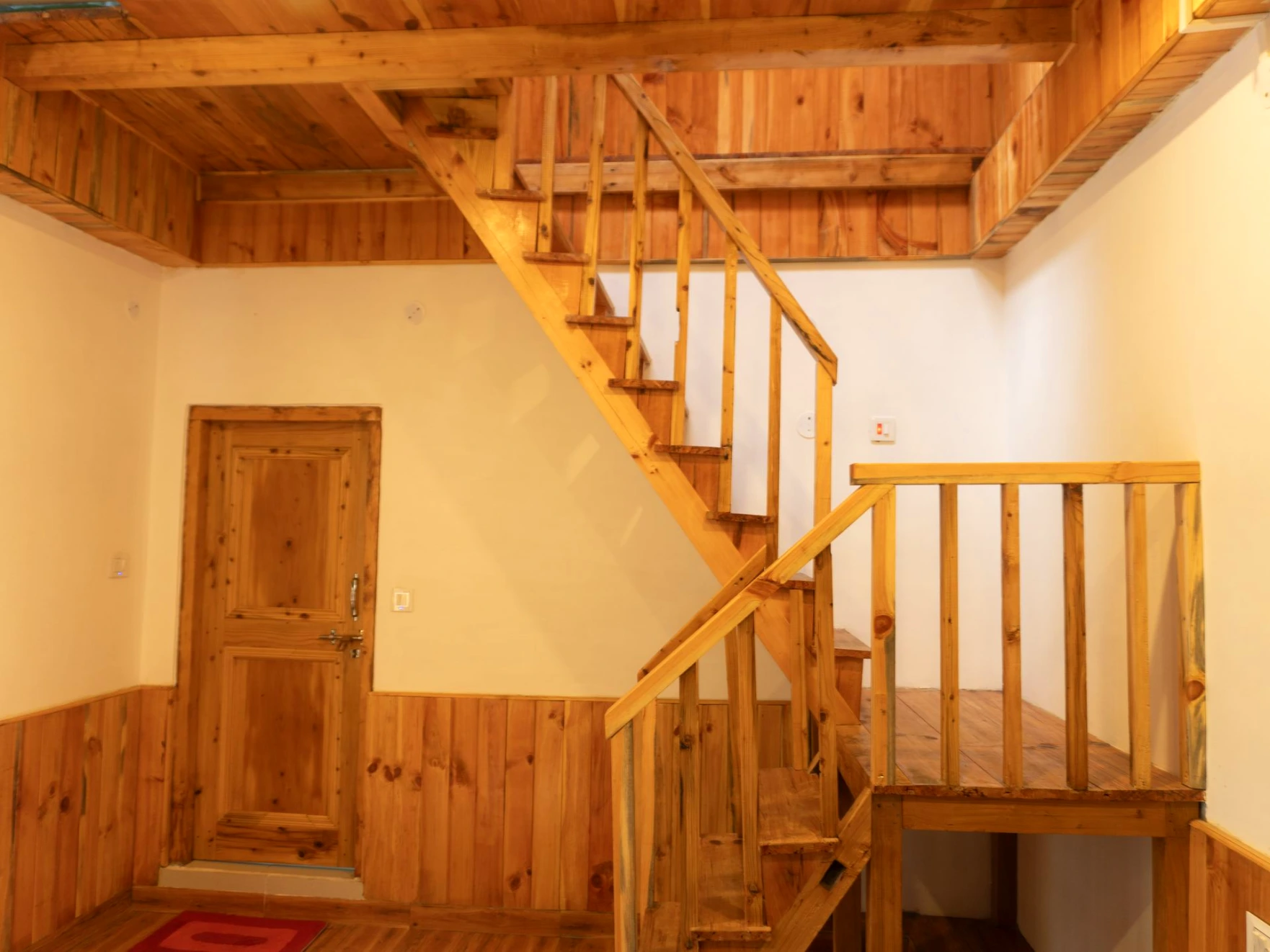 Duplex wooden room staircase at The River Haven Homestay in Tirthan Valley