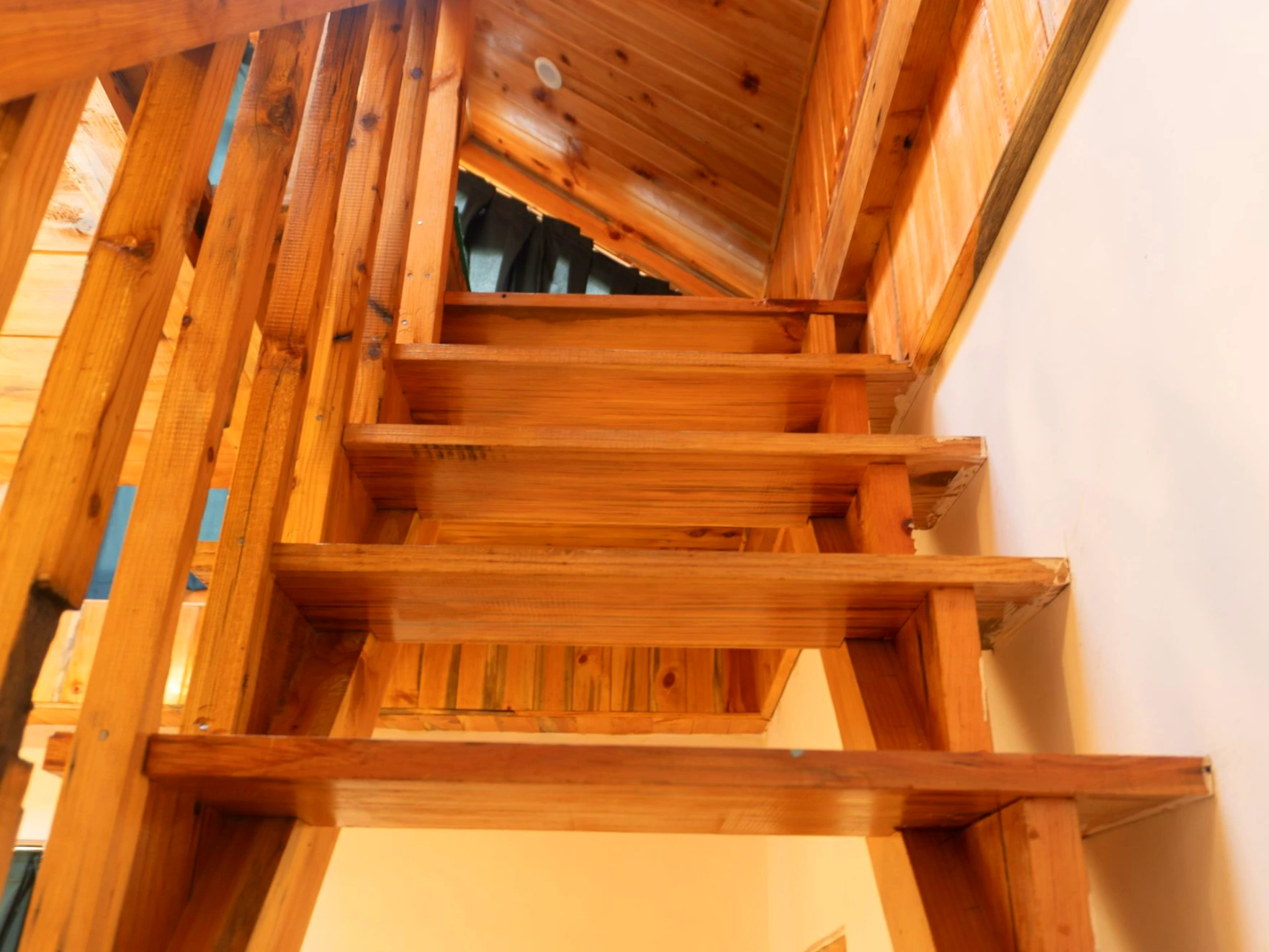Duplex wooden room staircase at The River Haven Homestay in Tirthan Valley