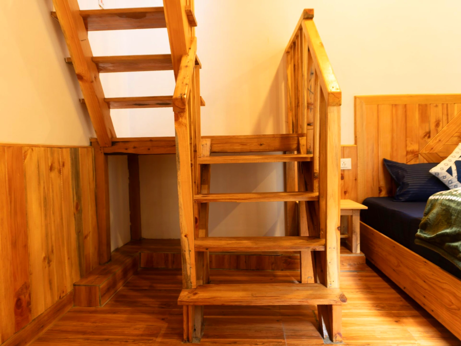 Duplex wooden room staircase at The River Haven Homestay in Tirthan Valley