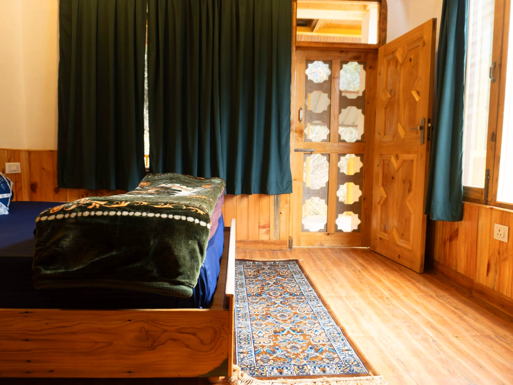 ComfortBalcony view surrounded by nature at The River Haven Homestay, Tirthan Valleyable bed with wooden interiors at The River Haven Homestay